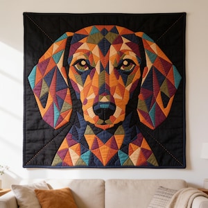 May include: A square wall hanging quilt featuring a geometric, multi-coloured mosaic portrait of a dog. The dog's face is composed of triangular fabric patches in shades of orange, purple, blue, green, and tan, set against a solid black background.