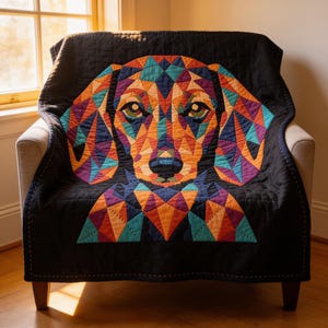 May include: A black quilt featuring a large, central geometric dog portrait composed of multicoloured triangular fabric patches in shades of orange, teal, purple, and yellow. The quilted fabric has a visible grid stitching pattern throughout.