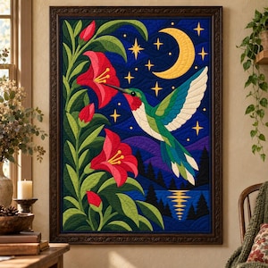 May include: A framed fabric wall hanging featuring a hummingbird in flight toward red trumpet-shaped flowers against a dark blue night sky with a yellow crescent moon and stars, above a silhouette of trees and a reflective body of water.