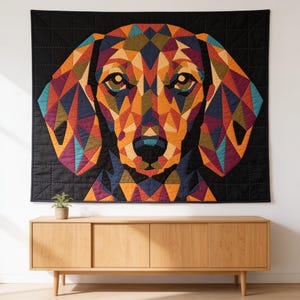 May include: A square wall hanging quilt featuring a geometric, multi-coloured dog portrait. The dog is composed of triangular patches in shades of orange, yellow, blue, purple, and green, set against a solid black background with grid stitching.