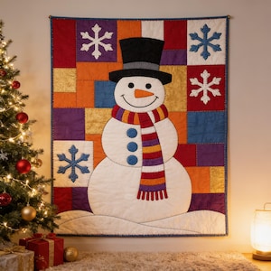 Könnte beinhalten: Ein rechteckiger Wandbehang mit einem zentralen weißen Schneemann, der einen schwarzen Zylinder und einen mehrfarbigen gestreiften Schal trägt. Der Hintergrund besteht aus einem Patchwork aus orangefarbenen, roten, violetten und blauen Quadraten.