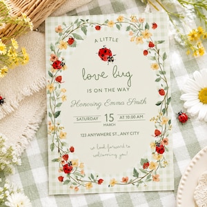 May include: A rectangular baby shower invitation card featuring a light green gingham background and an oval center. The text reads A LITTLE love bug IS ON THE WAY Honoring Emma Smith SATURDAY 15 MARCH AT 10:00 AM 123 ANYWHERE ST., ANY CITY.