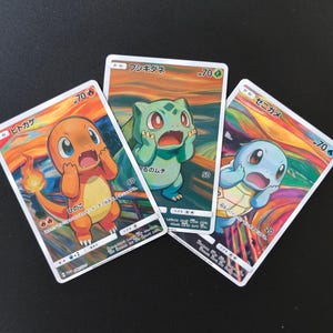 May include: Three rectangular trading cards featuring Japanese text and illustrations of Charmander, Bulbasaur, and Squirtle. Each character is depicted with a surprised expression against a swirling, colorful background reminiscent of The Scream painting.