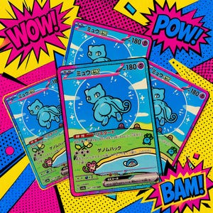 May include: Three Mew ex trading cards featuring a blue character illustration, 180 HP, and Japanese text. The cards are arranged in a fan shape against a vibrant pop art background with comic-style speech bubbles containing the words WOW, POW, and BAM.