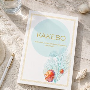 Pode incluir: Um livro Kakebo retangular com capa branca, borda dourada, um círculo azul-claro e o texto KAKEBO e Even dust, when piled up, becomes a mountain. A capa exibe um coral leque azul-petróleo e dois peixes de cor laranja.