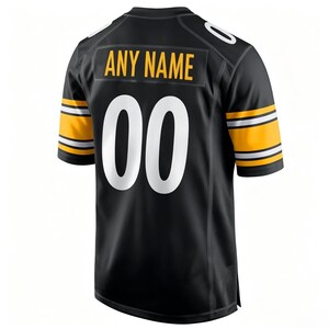 May include: A black sports jersey featuring short sleeves with yellow and white stripes. The back displays the text ANY NAME in yellow block letters above the large white number 00. The jersey has a V-neck collar and a standard athletic fit.