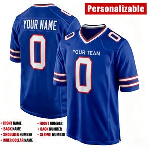 K&ouml;nnte beinhalten: Ein blaues Trikot mit wei&szlig;en und roten Akzenten, das den Text YOUR NAME und YOUR TEAM, die Nummer 0 sowie das Wort Personalizable zeigt. Das Design umfasst Nummern auf Vorderseite, R&uuml;cken, Schultern und &Auml;rmeln sowie einen inneren Kragenbereich.