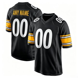 May include: A black football jersey featuring white numbers 00 on the front and back, with yellow and white stripes on the sleeves. The back displays the text ANY NAME in yellow letters above the number 00. The jersey has a V-neck collar.