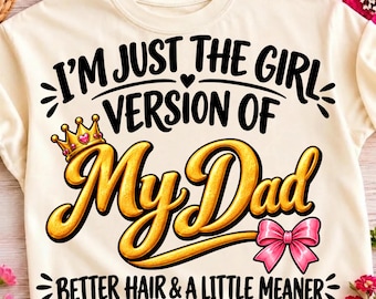 Puede incluir: Una camiseta de color crema con texto negro que dice I'M JUST THE GIRL VERSION OF MY DAD, BETTER HAIR & A LITTLE MEANER. La palabra MY DAD está en letra cursiva dorada grande, acompañada por una corona dorada con un corazón y lazo rosa.