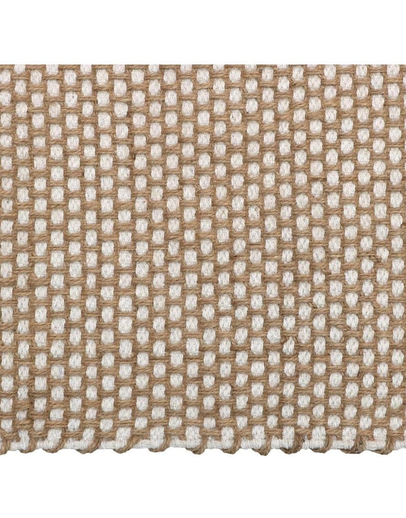 May include: A woven textile fabric featuring a repeating grid pattern created by alternating thick tan jute-like fibers and soft white cotton-like threads. The structure displays a consistent square weave with visible texture and depth throughout.