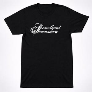May include: A black short-sleeved t-shirt featuring the white text Secondhand Serenade written in a cursive script font across the chest, accompanied by a small white five-pointed star symbol positioned to the right of the word Serenade.