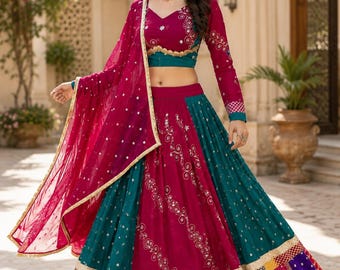 Peut inclure: Un ensemble lehenga choli magenta et bleu sarcelle composé d'un chemisier à manches longues, d'une jupe longue à panneaux brodés de motifs floraux et d'un dupatta magenta transparent avec une bordure dorée et des panneaux multicolores.