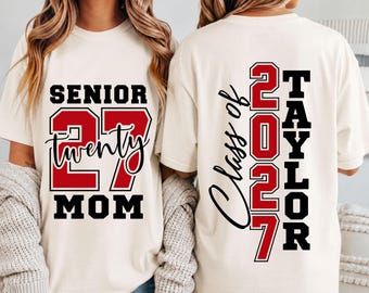 Könnte beinhalten: Ein cremefarbenes T-Shirt mit zwei grafischen Designs. Die Vorderseite zeigt den Text SENIOR 27 MOM mit dem Wort twenty in Schreibschrift. Die Rückseite zeigt den vertikalen Text Class of 2027 TAYLOR mit den Zahlen 2027 in großer roter Schrift.