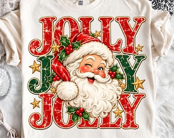 Könnte beinhalten: Ein cremefarbenes T-Shirt mit einer Grafik eines zwinkernden Weihnachtsmanns mit roter Mütze, umgeben von Stechpalmenbeeren, grünen Blättern und goldenen Sternen. Der Text JOLLY ist in großen, abgenutzten roten und grünen Buchstaben gedruckt.