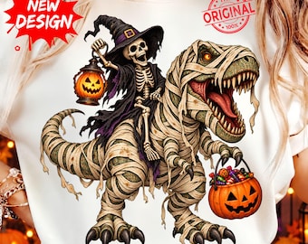 Può includere: Una t-shirt bianca con la grafica di uno scheletro con cappello da strega che tiene una lanterna a forma di zucca, in sella a un Tyrannosaurus Rex mummificato che trasporta un secchiello a forma di zucca pieno di caramelle colorate.