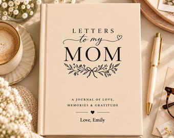 Könnte beinhalten: Ein cremefarbenes Notizbuch mit festem Einband und schwarzem Text, der Letters to my MOM, A JOURNAL OF LOVE, MEMORIES & GRATITUDE und Love, Emily lautet. Der Einband zeigt eine florale Zweigillustration und ein kleines Herzsymbol.