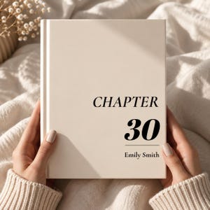 Puede incluir: Un libro de tapa dura con cubierta de color crema que presenta el texto negro "CHAPTER 30" centrado sobre el nombre "Emily Smith" en una fuente serif. El libro tiene un diseño limpio con una línea de lomo vertical en el lado izquierdo.