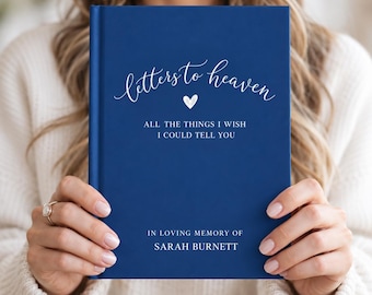 Könnte beinhalten: Ein dunkelblaues Hardcover-Notizbuch mit weißem Text, der "letters to heaven" in Schreibschrift, ein kleines Herzsymbol, "ALL THE THINGS I WISH I COULD TELL YOU" in Großbuchstaben und "IN LOVING MEMORY OF SARAH BURNETT" unten zeigt.
