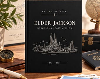 Könnte beinhalten: Ein schwarzes Hardcover-Notizbuch mit weißem Text, der CALLED TO SERVE, ELDER JACKSON, BARCELONA SPAIN MISSION und 2024-2026 lautet. Der Einband zeigt eine weiße Strichzeichnung der Skyline von Barcelona mit der Sagrada Familia.