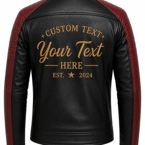 Pode incluir: Um casaco preto com painéis vermelho-escuros nos ombros e mangas. As costas apresentam um bordado dourado com o texto CUSTOM TEXT, Your Text, HERE e EST. 2024 com uma estrela. O casaco tem uma gola subida e um acabamento liso.