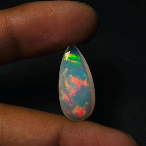 Ópalo etíope blanco natural en forma de pera, cabujón, ópalo de fuego Welo, gema suelta, ópalo rojo y verde brillante para la fabricación de joyas con colgantes y anillos (23,5 x 9,5 x 6 mm).
