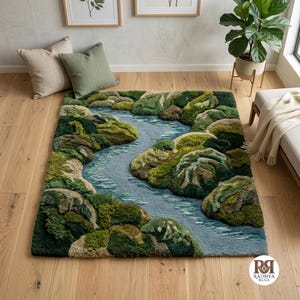 Puede incluir: Una alfombra rectangular con un diseño de paisaje texturizado y copetudo que muestra un río sinuoso de color azul claro que fluye a través de colinas en varios tonos de verde, oliva y marrón. La alfombra incluye el logo de Radhya Rugs.