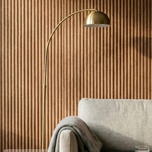 May include: A light gray upholstered sofa with a matching gray throw blanket draped over the arm, a clear acrylic side table, and a gold-toned arched floor lamp. A small glass candle holder with a lit tea light sits on the sofa cushion.