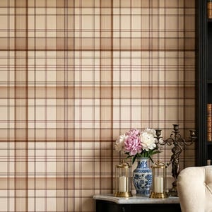 May include: Wallpaper featuring a classic plaid pattern in shades of beige, cream, and brown. The design consists of intersecting horizontal and vertical lines of varying thicknesses, creating a structured grid effect across the entire surface.