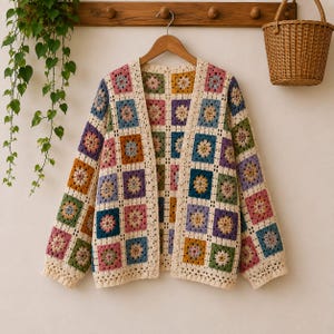 May include: A long-sleeve cardigan made of crocheted granny squares in various colors including pink, blue, yellow, green, and purple, joined by cream-colored yarn. The garment features an open front design with a straight hem and long sleeves.