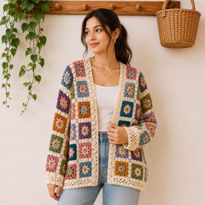 May include: A long-sleeved cardigan made of multi-colored crochet granny squares in shades of blue, pink, orange, and green, joined by cream-colored yarn. The open-front garment features a ribbed cream border along the neckline and front edges.