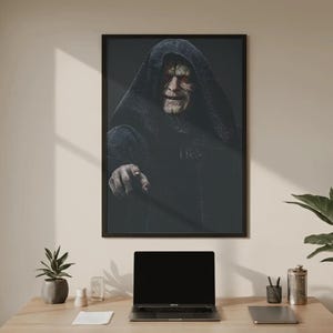 May include: A framed wall art print featuring a portrait of a pale, elderly figure with yellow eyes wearing a dark, textured hooded robe. The figure is depicted with a wrinkled face and a pointed finger extending forward against a dark background.