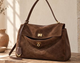 Bolso bandolera de piel de ante auténtica, con asa superior estructurada y correa de hombro ajustable.