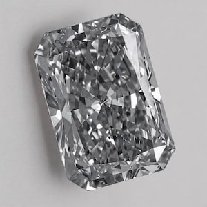 Può includere: Una pietra preziosa a taglio radiante di forma rettangolare con angoli smussati. La pietra è incolore e trasparente, caratterizzata da numerose sfaccettature triangolari e trapezoidali che creano un complesso motivo simmetrico di riflessi luminosi.