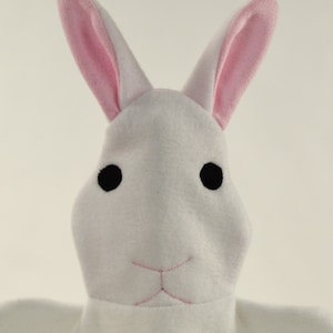 May include: White plush bunny rabbit with pink ears and black eyes. The bunny has a stitched pink nose and mouth.