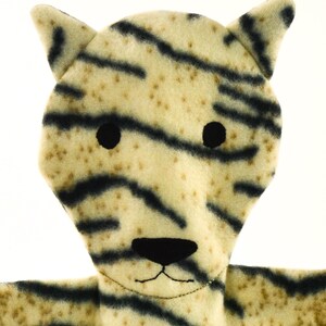 May include: A plush tiger puppet with a cream-colored body and black stripes. The puppet has black button eyes, a black nose, and a stitched mouth. The ears are triangular and the puppet is made of soft fabric.
