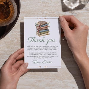 Pode incluir: Um cartão de agradecimento retangular branco com uma ilustração em aquarela de uma pilha de livros no topo. O texto diz: Thank you, A BIG THANK YOU TO OUR FAMILY AND FRIENDS FOR BEING A PART OF MY BRIDAL SHOWER, I GREATLY APPRECIATE YOUR LOVE & SUPPORT, WELL WISHES AND THANK YOU FOR THE GENEROUS GIFT YOU GAVE, I WILL ALWAYS REMEMBER HOW MUCH I LOVED CELEBRATING MY SPECIAL DAY WITH YOU, Love, Emma.