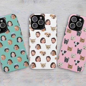 May include: Three smartphone cases featuring repeating patterns of faces. The left case is teal with children's faces. The center case is white with a mix of human and pet faces. The right case is pink with a repeating pattern of cat and dog faces.