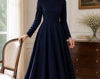 May include: A solid navy blue midi dress featuring long sleeves, a round neckline, and a fitted bodice that transitions into a full, flared skirt. The garment is worn with sheer black tights and black pointed-toe high-heeled pumps.