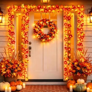 May include: A white front door decorated with an illuminated maple leaf garland and a matching wreath featuring orange, red, and yellow leaves. Two large planters filled with autumn foliage, pinecones, and pumpkins flank the entrance.