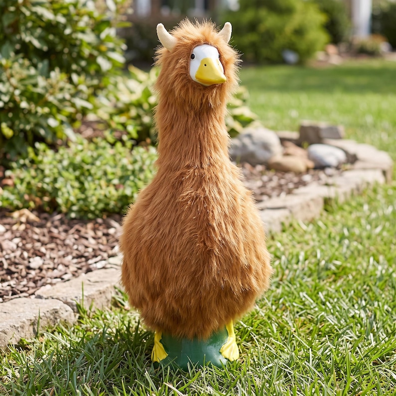 May include: A plush stuffed animal featuring a brown, shaggy, long-haired body with a white face, a yellow beak, and two small, upright, cream-colored horns on top of its head. The creature stands on two yellow webbed feet.