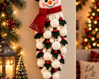 May include: A crocheted snowman wall hanging featuring a black top hat with red berries, a red scarf, and a long, tapered body made of white yarn spheres interspersed with dark green crocheted leaves and small red berries, suspended by a loop.