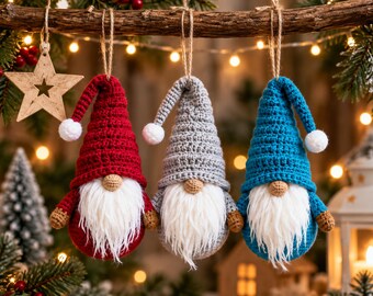 May include: Three crocheted gnome ornaments hanging from a branch. Each gnome features a tall pointed hat in red, gray, or blue, a white faux fur beard, a small tan nose, and a white pom-pom at the tip of the hat. Each is suspended by twine.