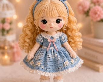 May include: A handcrafted crochet doll with long curly blonde hair, wearing a blue dress with white floral embroidery, a white lace collar, and a matching blue headband with small ears. The doll has black eyes, pink cheeks, and blue shoes.