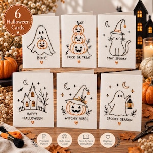 Puede incluir: Seis tarjetas de felicitación blancas con diseños de Halloween bordados en negro y naranja. Las tarjetas muestran un fantasma con calabaza, calabazas apiladas, un gato con sombrero de bruja, una casa encantada, una calabaza y un fantasma.