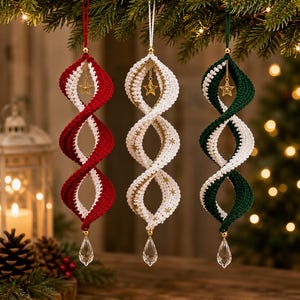 May include: Three hanging spiral ornaments made of crocheted yarn in red, white, and green. Each ornament features a gold-toned star charm suspended inside the spiral and a clear, faceted crystal teardrop pendant attached to the bottom point.