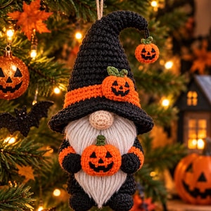Peut inclure: Une décoration de gnome au crochet avec un grand chapeau pointu noir orné d'une bande orange et d'une petite citrouille. Le gnome possède un nez beige, une longue barbe en laine blanche et des vêtements noirs, tenant une citrouille.