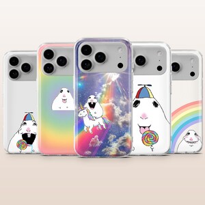 May include: Five clear smartphone cases featuring various illustrations of a white hamster. Designs include a hamster with a lollipop and propeller hat, a hamster riding a unicorn in a cosmic sky with a rainbow, and a hamster near a rainbow.