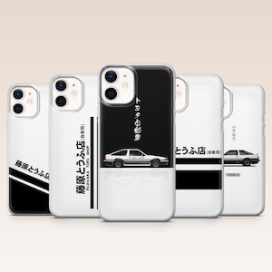 May include: Five clear smartphone cases featuring black and white graphic designs of a classic AE86 sports car. The designs include Japanese text characters and the English phrase Fujiwara Tofu Shop, with various layouts of black stripes and blocks.