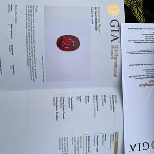 Op de afbeelding: Een GIA-edelsteenrapport voor een natuurlijke robijn van 2,10 karaat in kussenvorm uit Madagaskar. Het document toont de rode kleur, transparantie en afmetingen van 8,59 x 6,03 x 4,51 mm, inclusief details over de kroon- en paviljoenslijpvormen.