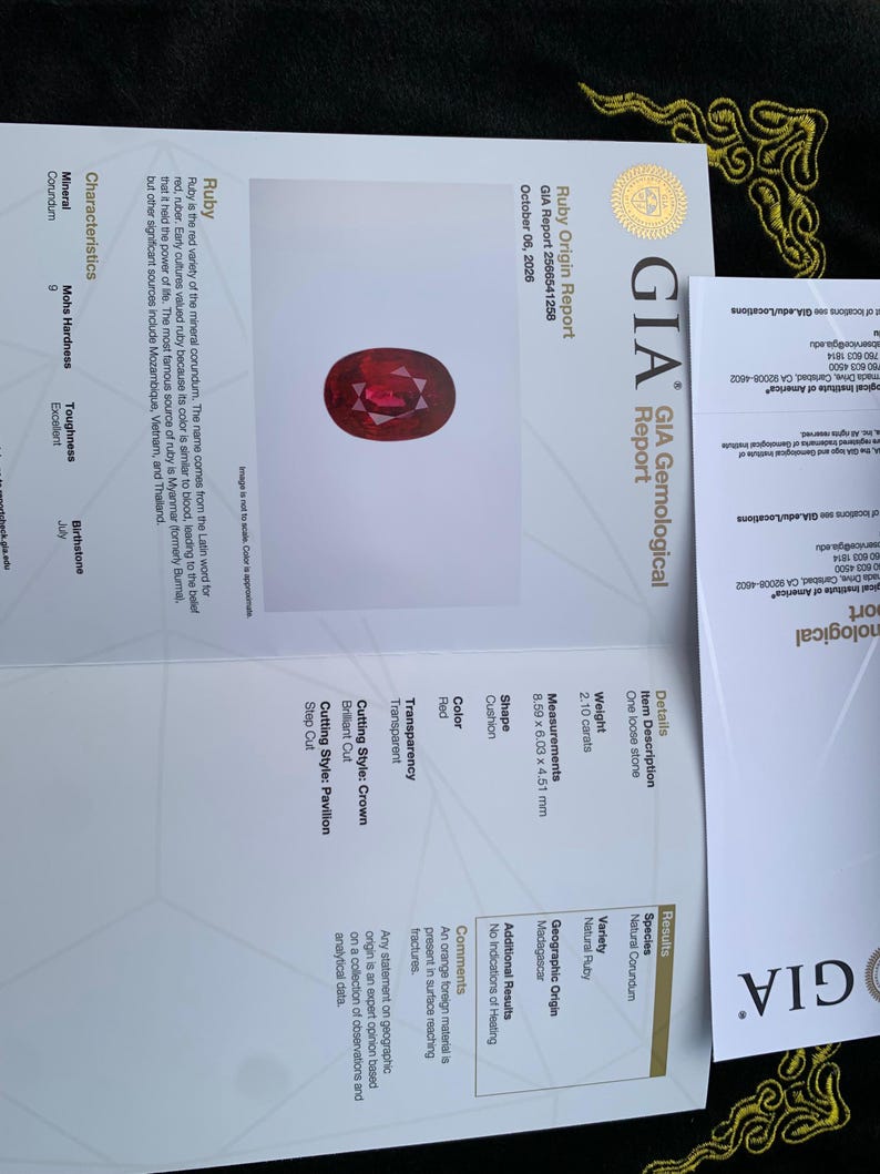 Op de afbeelding: Een GIA-edelsteenrapport voor een natuurlijke robijn van 2,10 karaat in kussenvorm uit Madagaskar. Het document toont de rode kleur, transparantie en afmetingen van 8,59 x 6,03 x 4,51 mm, inclusief details over de kroon- en paviljoenslijpvormen.